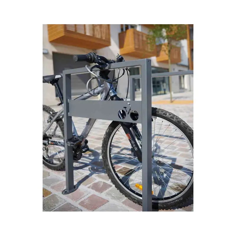Fahrradbügel Milano mit Quersteg und Fahrrad-Piktogramm sowie diebstahlsicher angeschlossenem Mountainbike im Außenbereich.