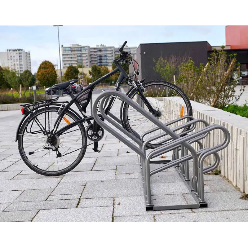 Stabiler Fahrradständer Optimum mit versetzter Hoch- und Tiefeinstellung und eingeparktem Fahrrad im städtischen Außenbereich.