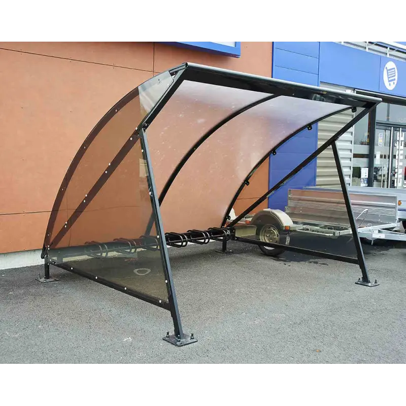 Fahrradunterstand Halbmond mit getönten Polycarbonatscheiben und integriertem Bügelständer vor einem Geschäftsgebäude