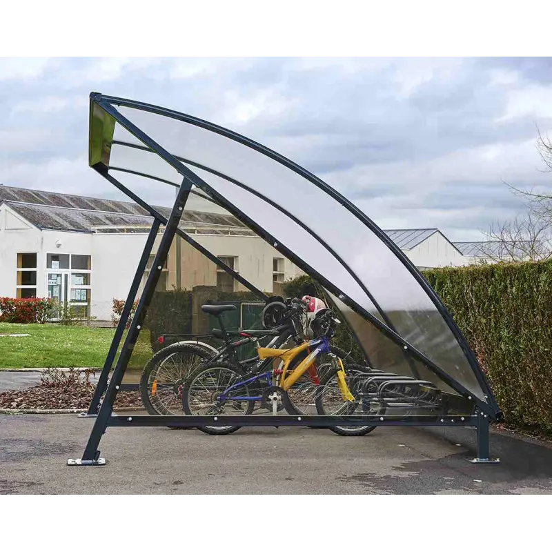 Seitenansicht der geschwungenen Fahrradüberdachung Halbmond mit transparenter Seitenwandverkleidung und abgestellten Fahrrädern.