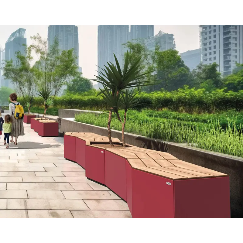 Reihe aus roten Kairo-Sitzbänken und Pflanzmodulen entlang einer modernen Uferpromenade vor städtischer Skyline.